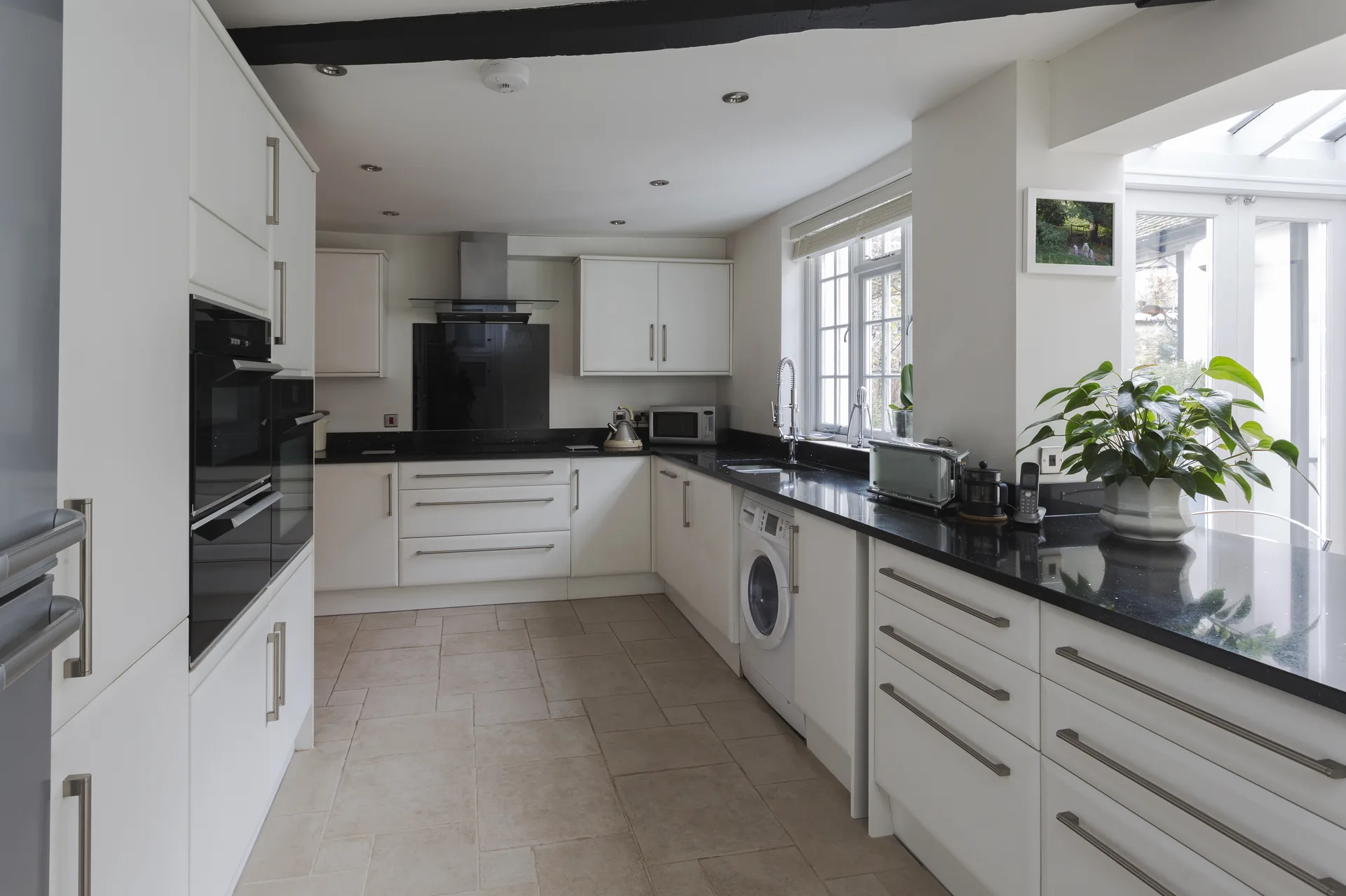 Reforma cocina Zaragoza en blanco y negro con azulejo chevron y encimera negra